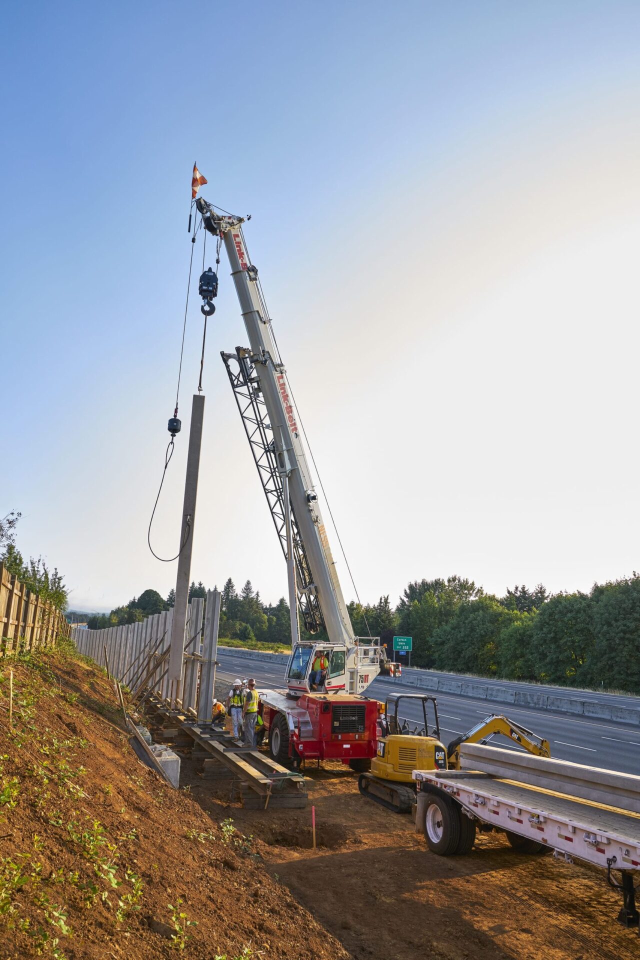 Link-Belt rough terrain crane setting a concrete barrier on a highway jobsite