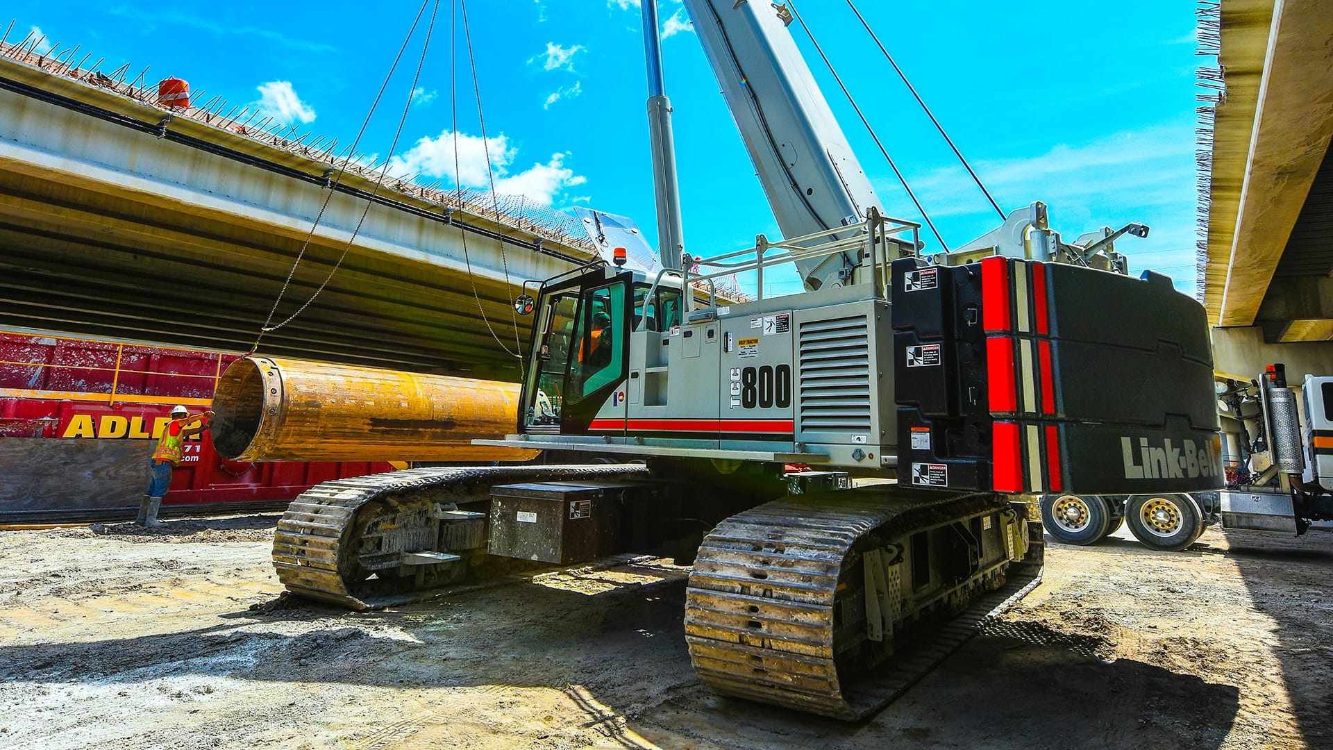Link-Belt telescopic crawler crane lifting a precast girder on a bridge jobsite