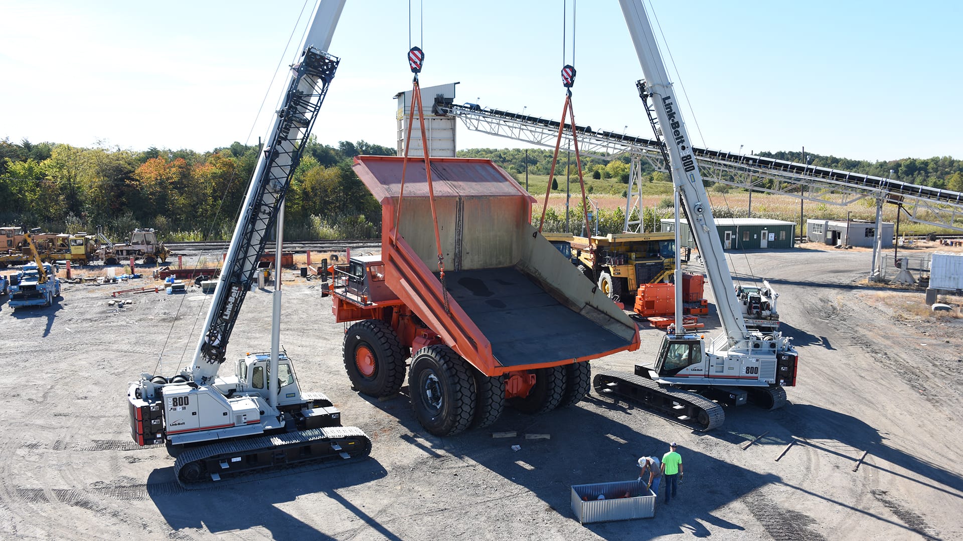 Two Link-Belt TCC-800 telescopic crawler cranes making a tandem lift of a haul truck bed